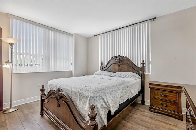 bedroom with baseboards and light wood finished floors