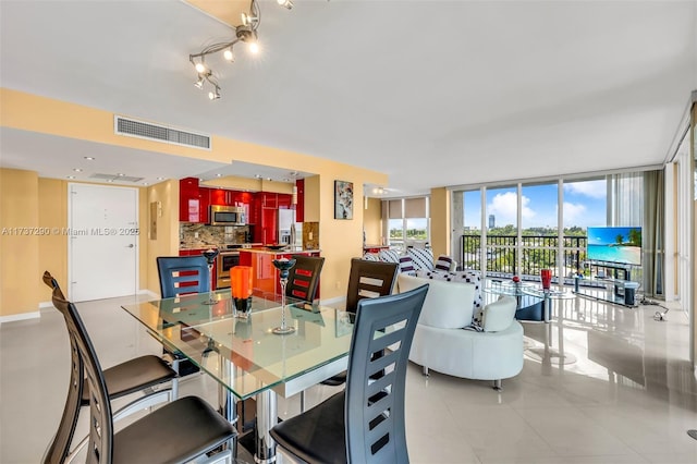 tiled dining room featuring floor to ceiling windows