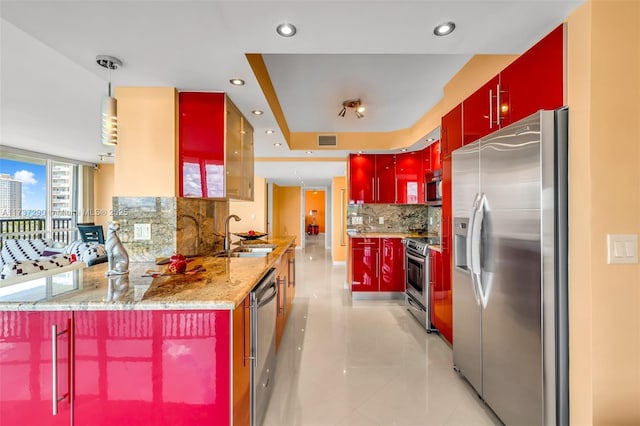 kitchen featuring pendant lighting, stainless steel appliances, kitchen peninsula, and sink