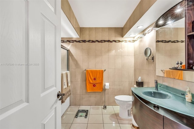 bathroom featuring tile patterned floors, toilet, tile walls, and vanity