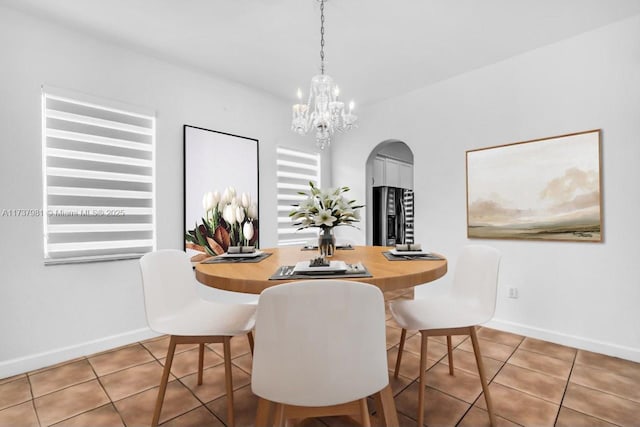 dining space with tile patterned flooring and a chandelier