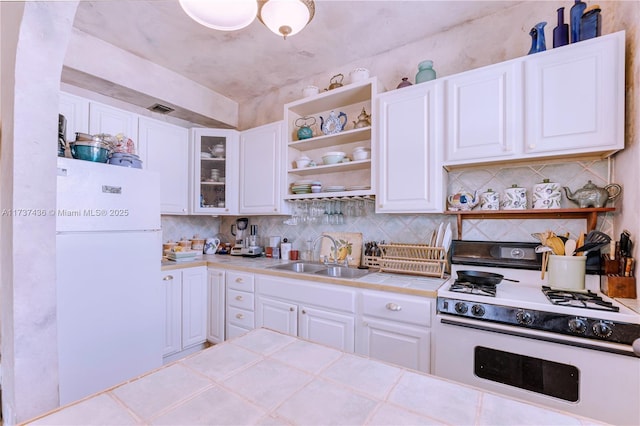 kitchen with tile countertops, sink, white cabinets, decorative backsplash, and white appliances