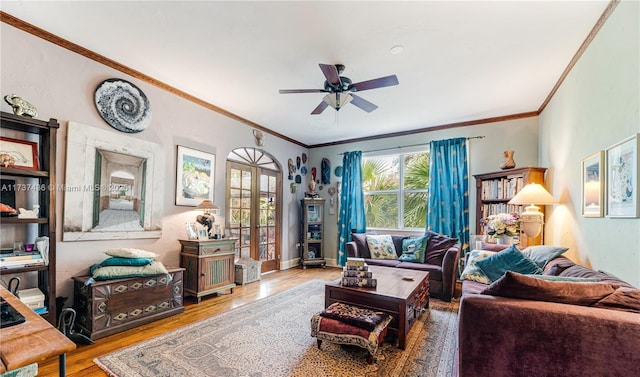 living room featuring hardwood / wood-style flooring, ornamental molding, ceiling fan, and french doors