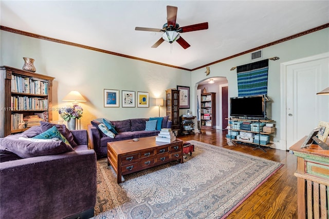 living room featuring dark wood-type flooring, ornamental molding, and ceiling fan