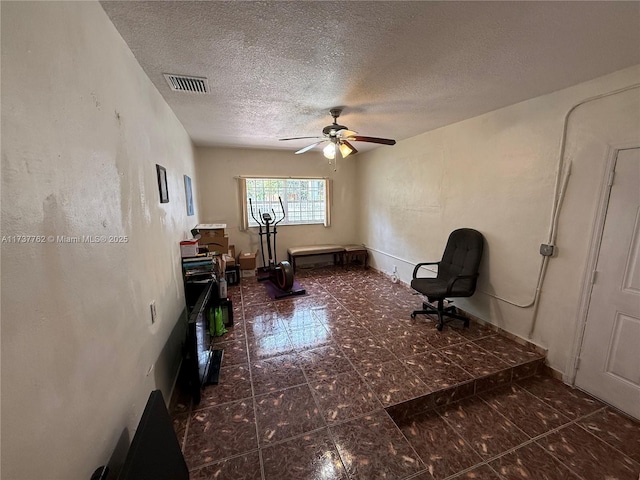 sitting room featuring ceiling fan and a textured ceiling