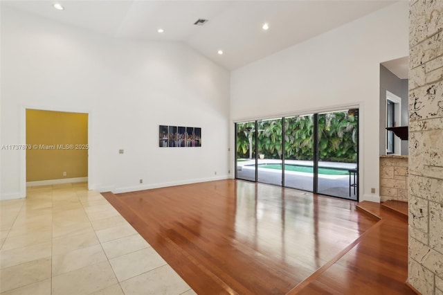 tiled living room featuring high vaulted ceiling