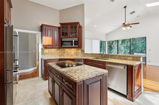 kitchen featuring sink, vaulted ceiling, appliances with stainless steel finishes, a kitchen island, and backsplash