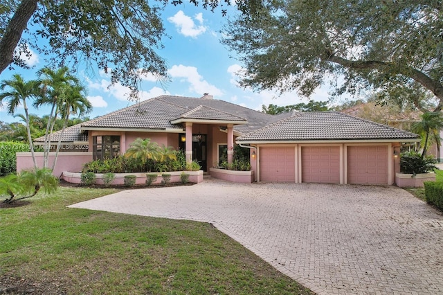 view of front facade with a garage and a front lawn