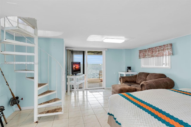 bedroom with access to exterior, floor to ceiling windows, and light tile patterned flooring