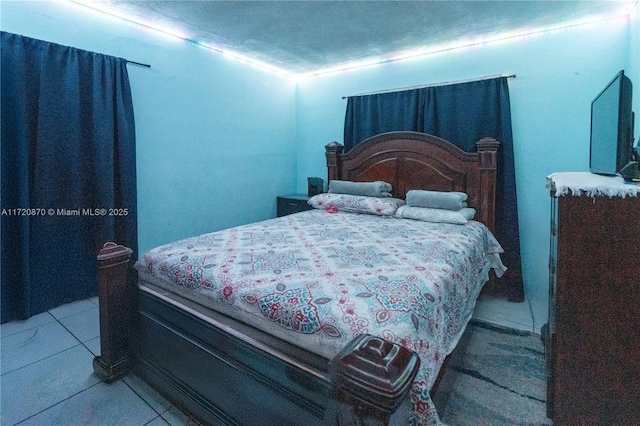 bedroom with light tile patterned flooring and a textured ceiling