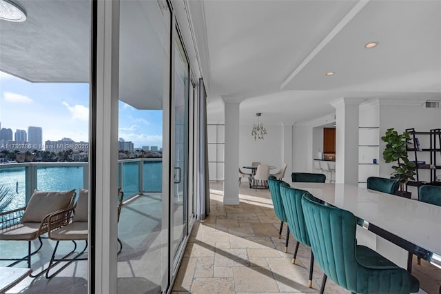 dining area with floor to ceiling windows, a water view, and a chandelier