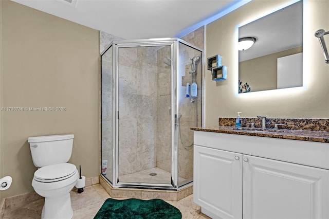 bathroom with vanity, tile patterned floors, toilet, and walk in shower