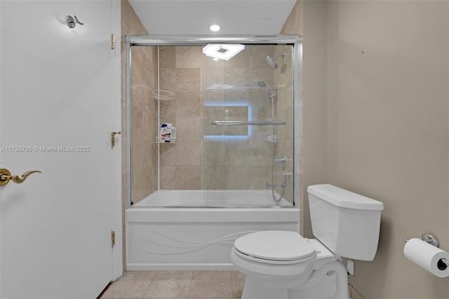 bathroom featuring bath / shower combo with glass door, tile patterned floors, and toilet