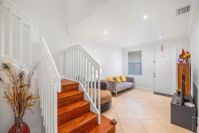 tiled foyer featuring crown molding