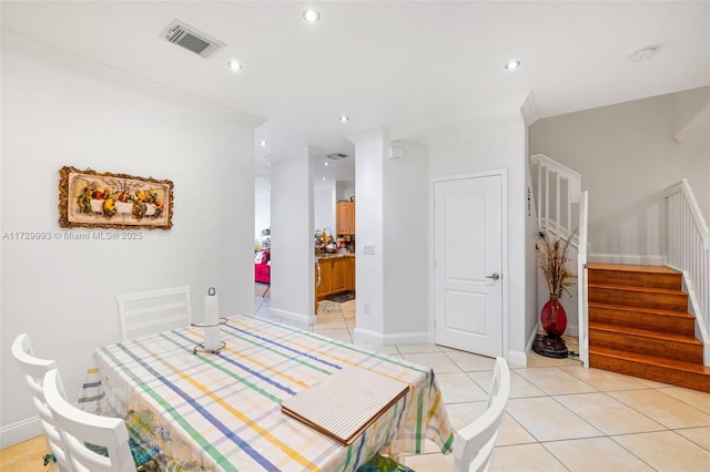 dining area with ornamental molding and light tile patterned floors