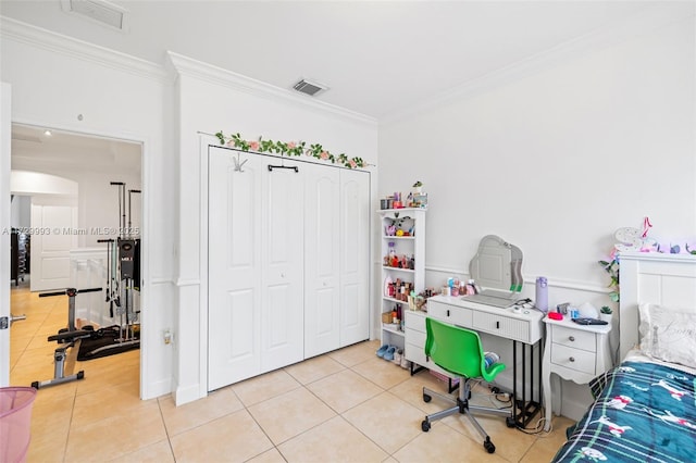 tiled bedroom with crown molding and a closet