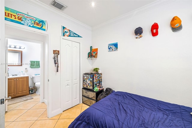 bedroom featuring ornamental molding, light tile patterned floors, and a closet