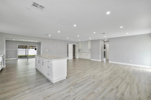 kitchen featuring white cabinetry, a kitchen island, and light wood-type flooring