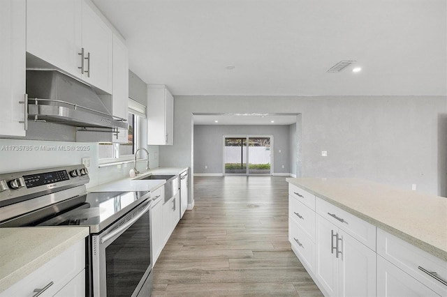 kitchen featuring light hardwood / wood-style flooring, sink, stainless steel electric range, and white cabinets