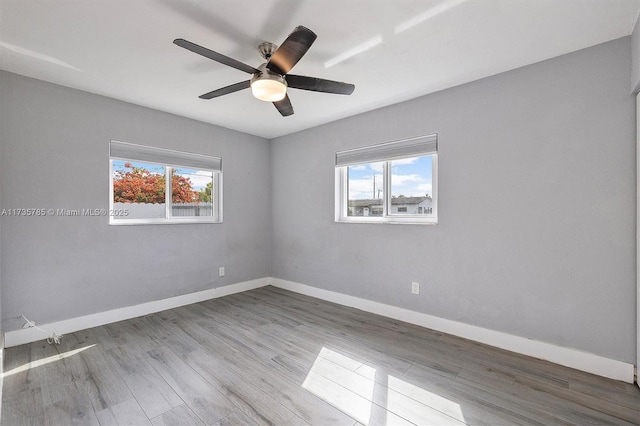 spare room featuring light hardwood / wood-style flooring, a wealth of natural light, and ceiling fan