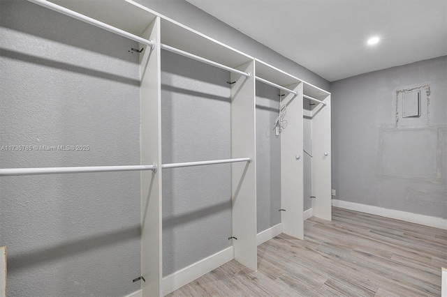 walk in closet with light hardwood / wood-style flooring