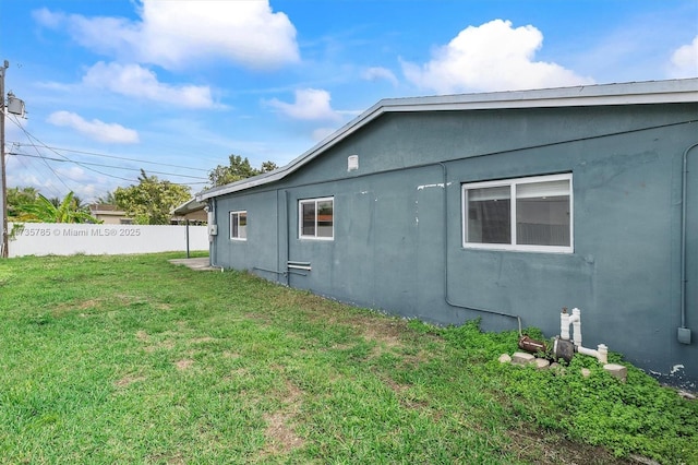 view of side of home with a yard