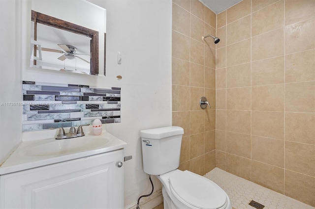 bathroom with a tile shower, vanity, toilet, and ceiling fan