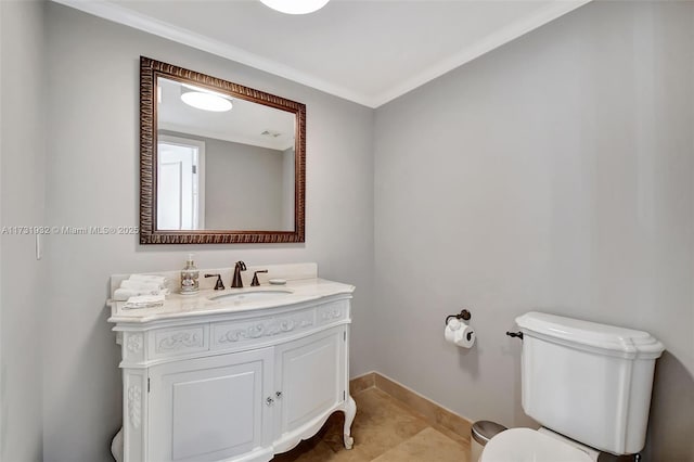 bathroom featuring tile patterned flooring, vanity, ornamental molding, and toilet