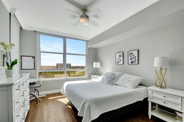 bedroom featuring hardwood / wood-style floors, ornamental molding, and ceiling fan