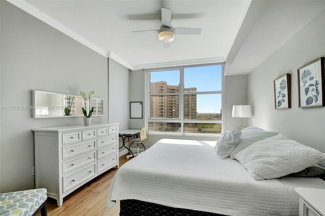 bedroom featuring crown molding, light hardwood / wood-style floors, and ceiling fan