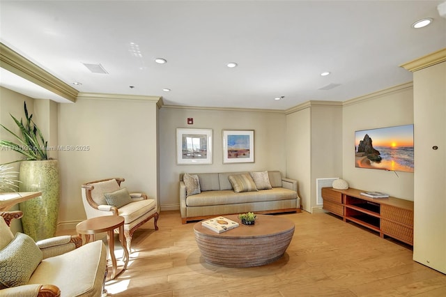 living room featuring crown molding and light hardwood / wood-style flooring