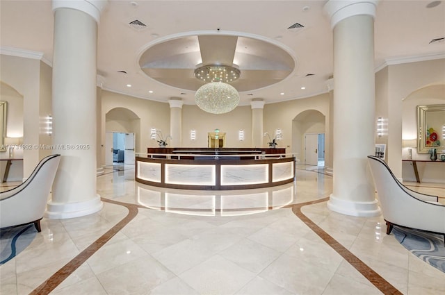 welcome area with ornate columns and an inviting chandelier