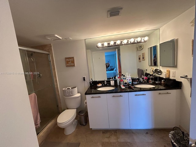 bathroom featuring an enclosed shower, vanity, and toilet