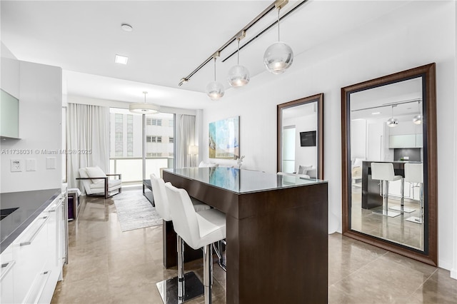 kitchen featuring decorative light fixtures, a kitchen island, and white cabinets