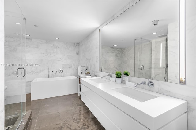 bathroom featuring independent shower and bath, vanity, and tile walls