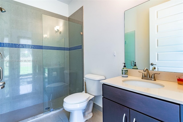 bathroom featuring tile patterned floors, vanity, toilet, and a shower with door