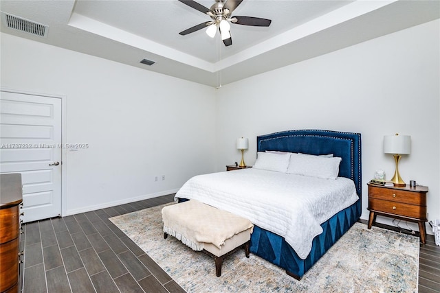 bedroom with a raised ceiling and ceiling fan