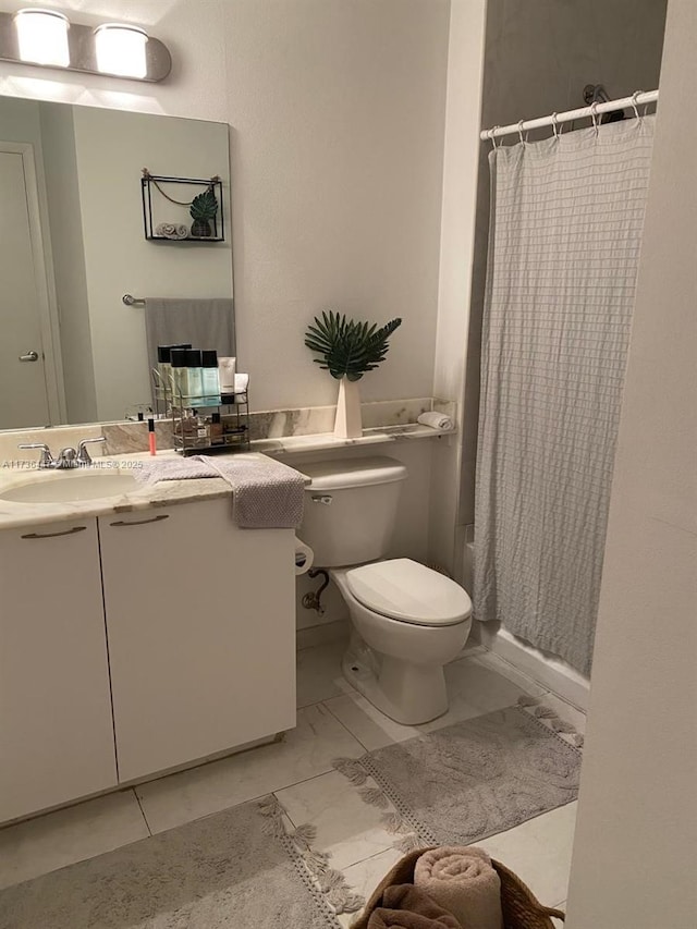 full bathroom featuring marble finish floor, vanity, and toilet