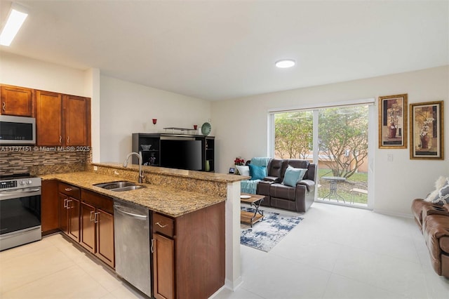 kitchen with sink, backsplash, kitchen peninsula, and appliances with stainless steel finishes