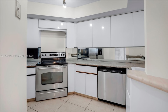 kitchen with light tile patterned flooring, appliances with stainless steel finishes, and white cabinets