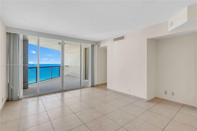 tiled empty room featuring a water view