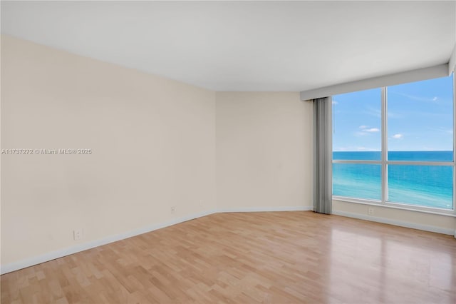 empty room with a water view and light hardwood / wood-style floors