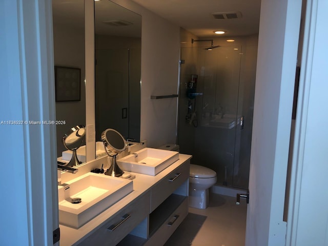 bathroom with vanity, toilet, and a shower with door