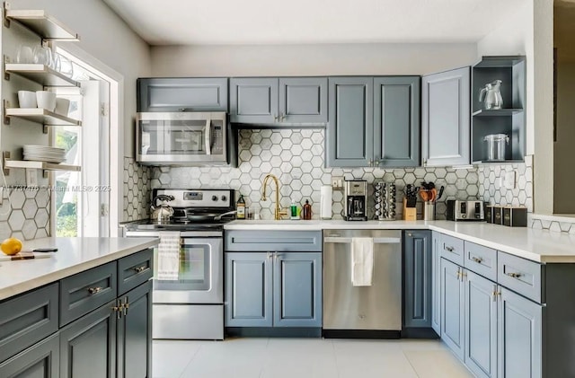 1528 NE 17th Ter, Fort Lauderdale, FL 33304 - kitchen featuring light countertops, stainless steel appliances, tasteful backsplash, and open shelves