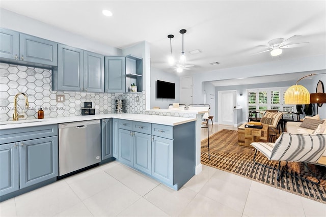 kitchen featuring open floor plan, a peninsula, stainless steel dishwasher, and a sink