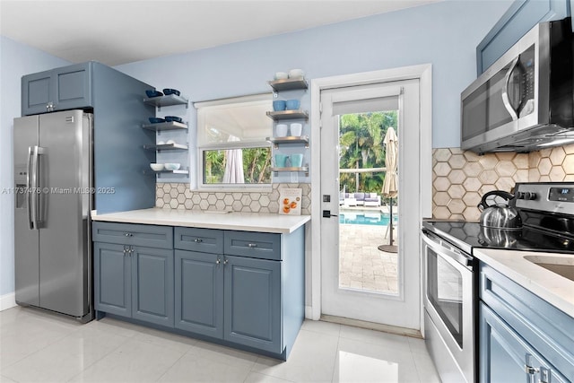 kitchen with stainless steel appliances, light countertops, backsplash, and open shelves