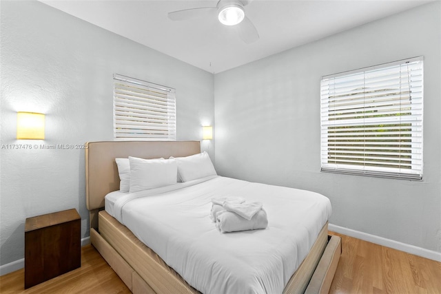 bedroom featuring baseboards, ceiling fan, and light wood-style floors