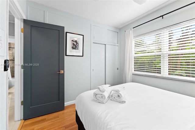 bedroom with light wood-type flooring and a closet