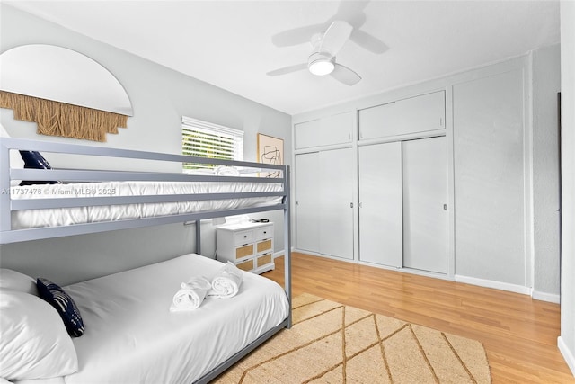 bedroom with light wood-style flooring, a ceiling fan, and a closet