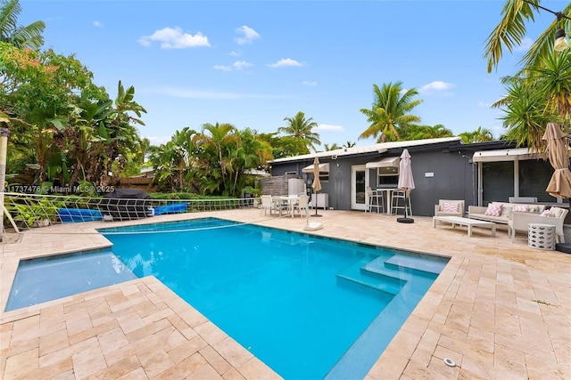 view of swimming pool featuring a fenced in pool, outdoor lounge area, a patio, and fence